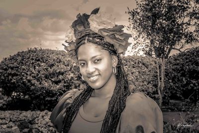 Portrait of smiling young woman against plants