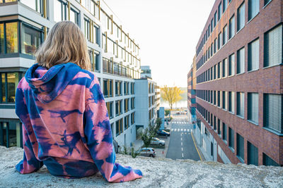 Rear view of girl in front of buildings