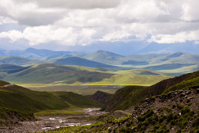 Scenic view of valley and mountains against sky