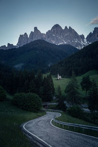 Road by mountains against sky