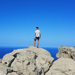 Man standing on rocks at beach