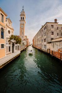 Motor boat sailing past the church of san giorgio dei greci with its typical leaning bell tower