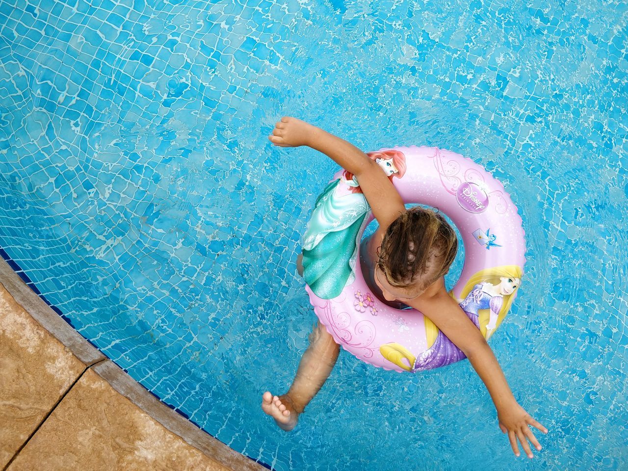 swimming pool, child, childhood, water, high angle view, children only, summer, full length, smiling, girls, inflatable ring, one person, one girl only, playing, cheerful, directly above, happiness, fun, enjoyment, people, day, vacations, swimming, floating on water, lying down, outdoors, portrait, adult
