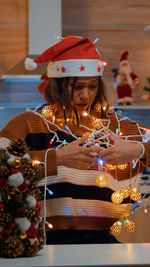 Young woman holding lighting equipment at home