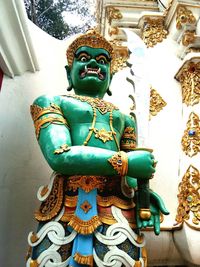 Low angle view of buddha statue against building