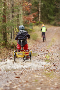 Child cycling through puddle