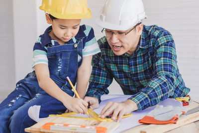 Engineer assisting son in making drawing