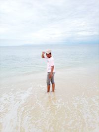 Full length of man standing on beach against sky