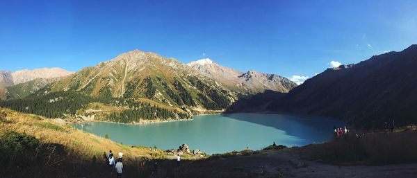 Panoramic view of lake and mountains against clear blue sky