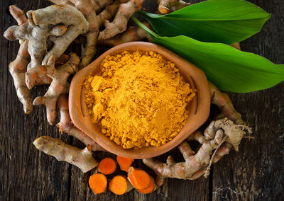 High angle view of spices and leaves on wood