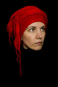 Close-up portrait of a young woman against black background