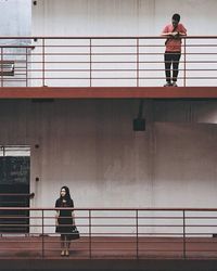 Full length of woman standing by railing