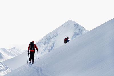 People on snowcapped mountain against sky