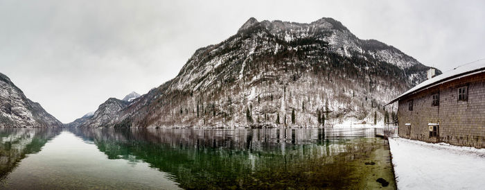 Panoramic view of lake by snowcapped mountain against sky