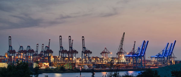 Panorama view on cranes in habour against fading sky light