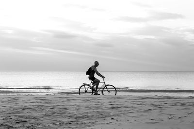 Man riding bicycle on beach