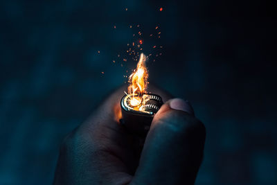 Midsection of person holding sparkler at night