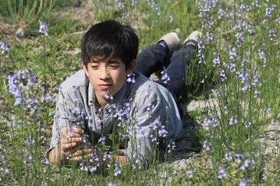 Portrait of boy with flowers on grass