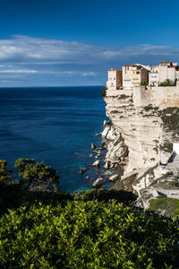 View of building by sea against blue sky