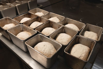 The dough for baking bread lies in bread metal forms. dough sprinkled with sunflower seeds. bread