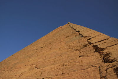 Low angle view of mountain against blue sky