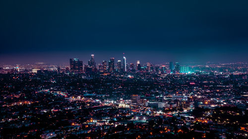 Illuminated cityscape against sky at night