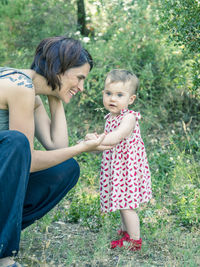 Mother and daughter sitting on grass