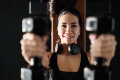 Young woman using mobile phone while standing in gym