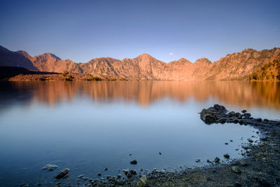 Calm lake against rocky mountains