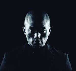 Portrait of man against black background