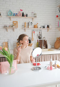 Portrait of young woman having food at home