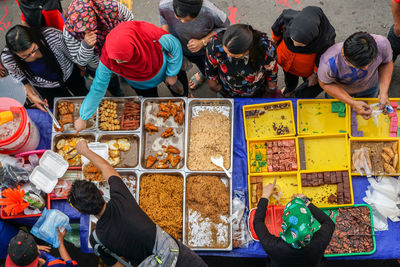 High angle view of people for sale at market stall