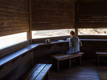 Full length of girl sitting in hideout at umkhuzi game reserve, south africa