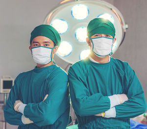 A doctor from asia stands in his operating room office.