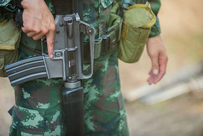 Midsection of soldier with gun