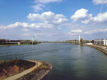 Bridge over river against cloudy sky