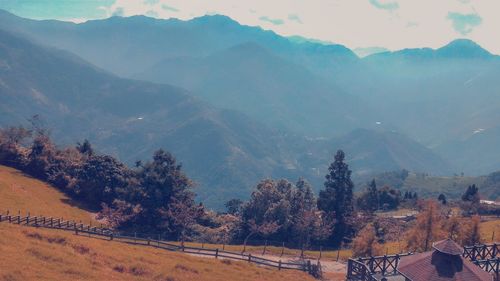 Scenic view of field and mountains against sky