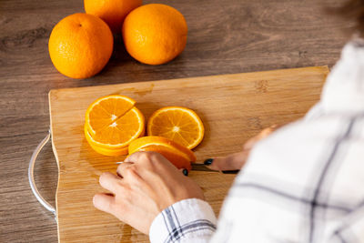 Midsection of man holding oranges on table