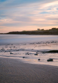 Scenic view of beach against sky during sunset
