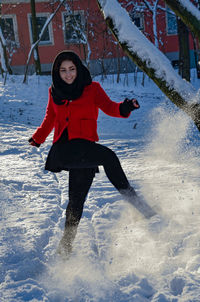 Happy young woman playing with snow
