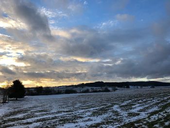 Scenic view of snow field against sky during sunset