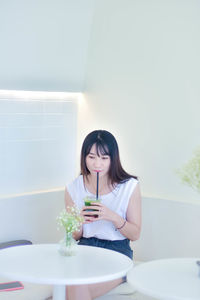 Portrait of smiling young woman sitting at home