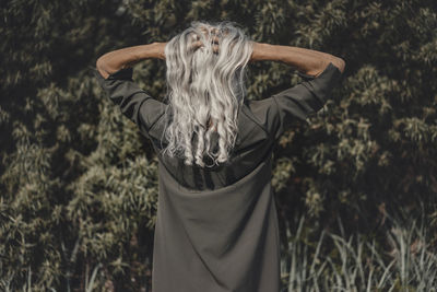 Rear view of senior woman with hands in her white hair