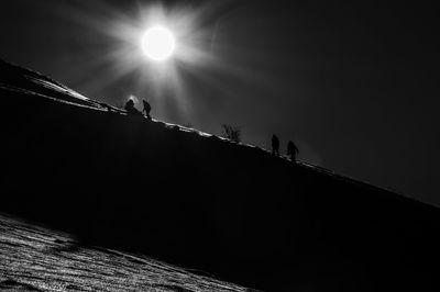 Low angle view of silhouette people against bright sun
