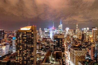 Illuminated buildings in city against sky at night