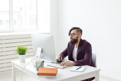 Young man using mobile phone while sitting on table