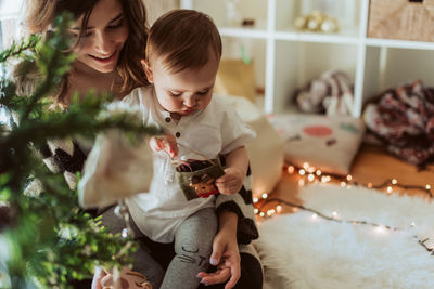 Mother and girl sitting on christmas tree