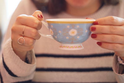 Midsection of woman holding coffee cup