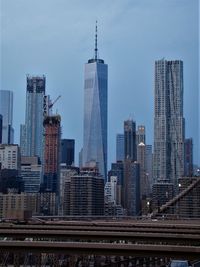 One world trade center in city against sky at dusk