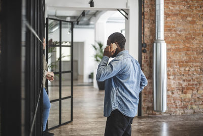 Male entrepreneur talking on smart phone at startup company